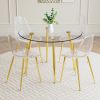 A modern minimalist style round transparent tempered glass table with gold metal legs